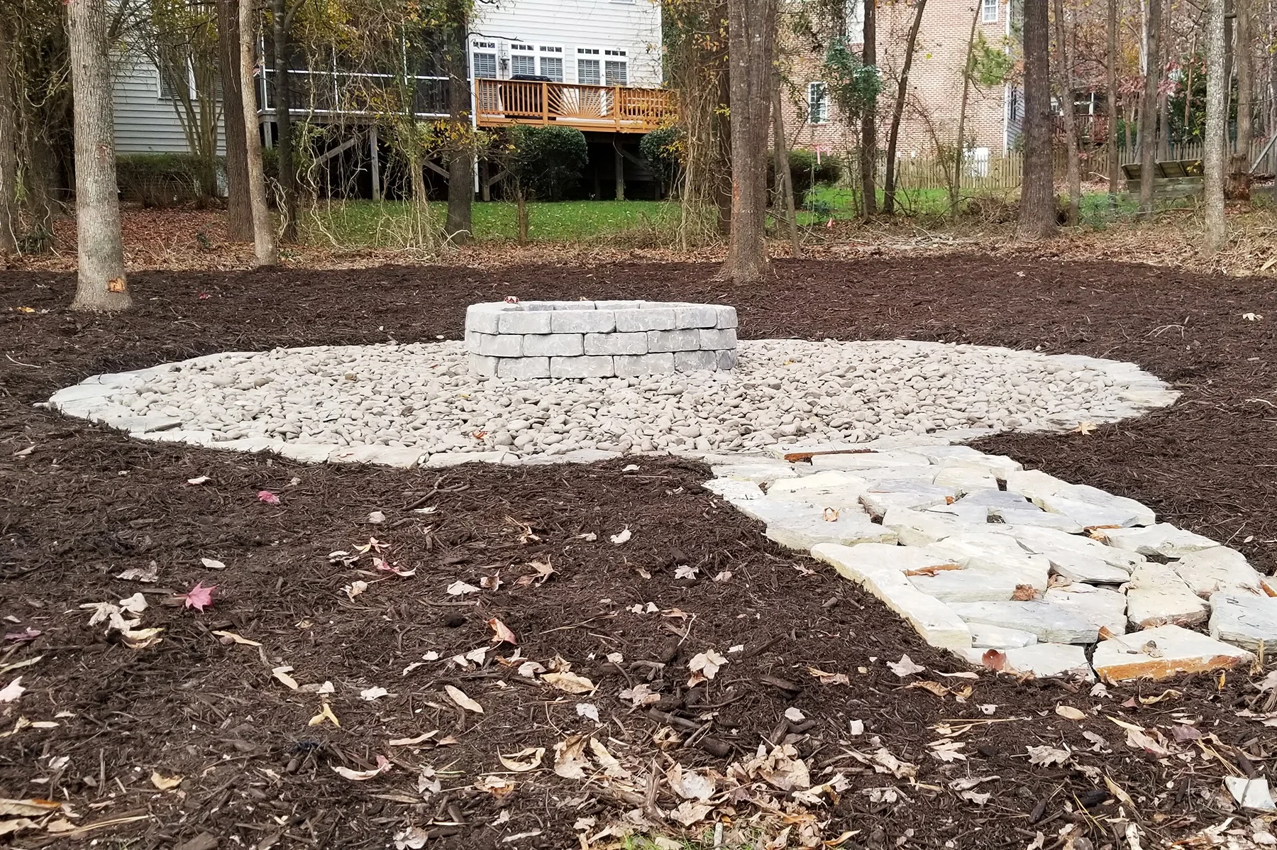 Custom stone fire pit with boulder seating area