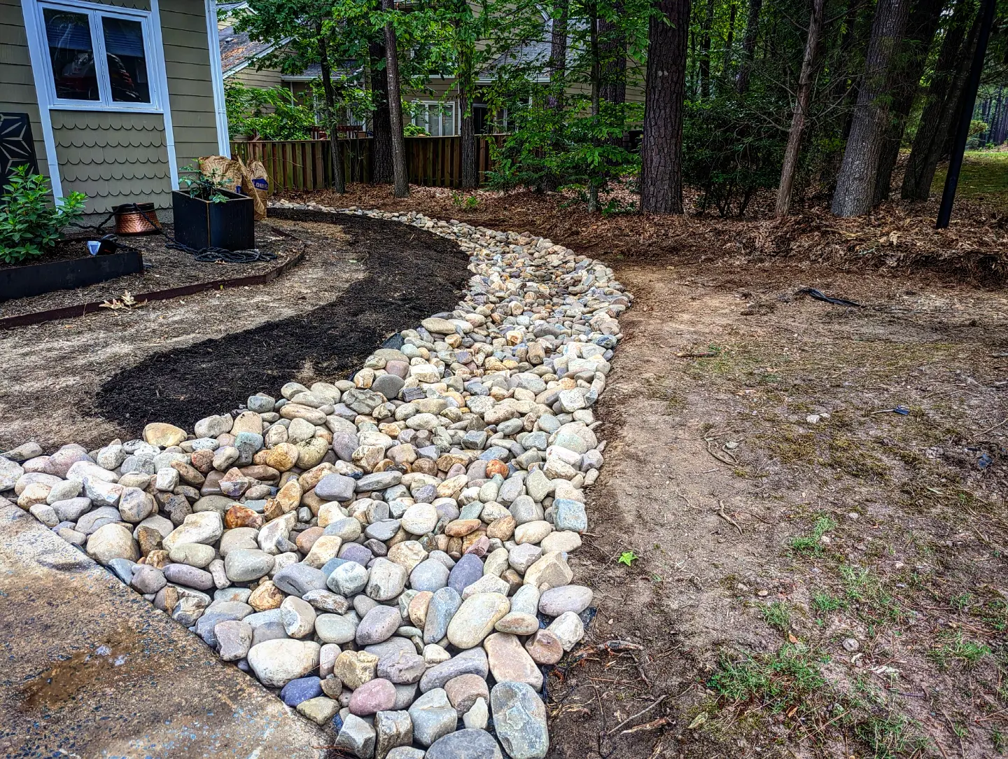 Stone creek bed winding through residential landscape