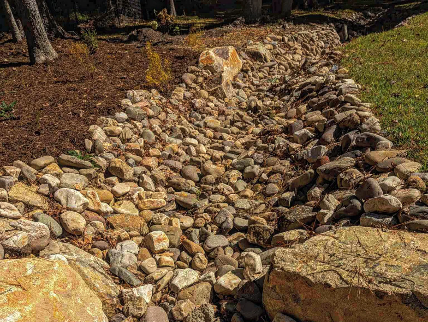 Completed natural stone creek bed drainage feature